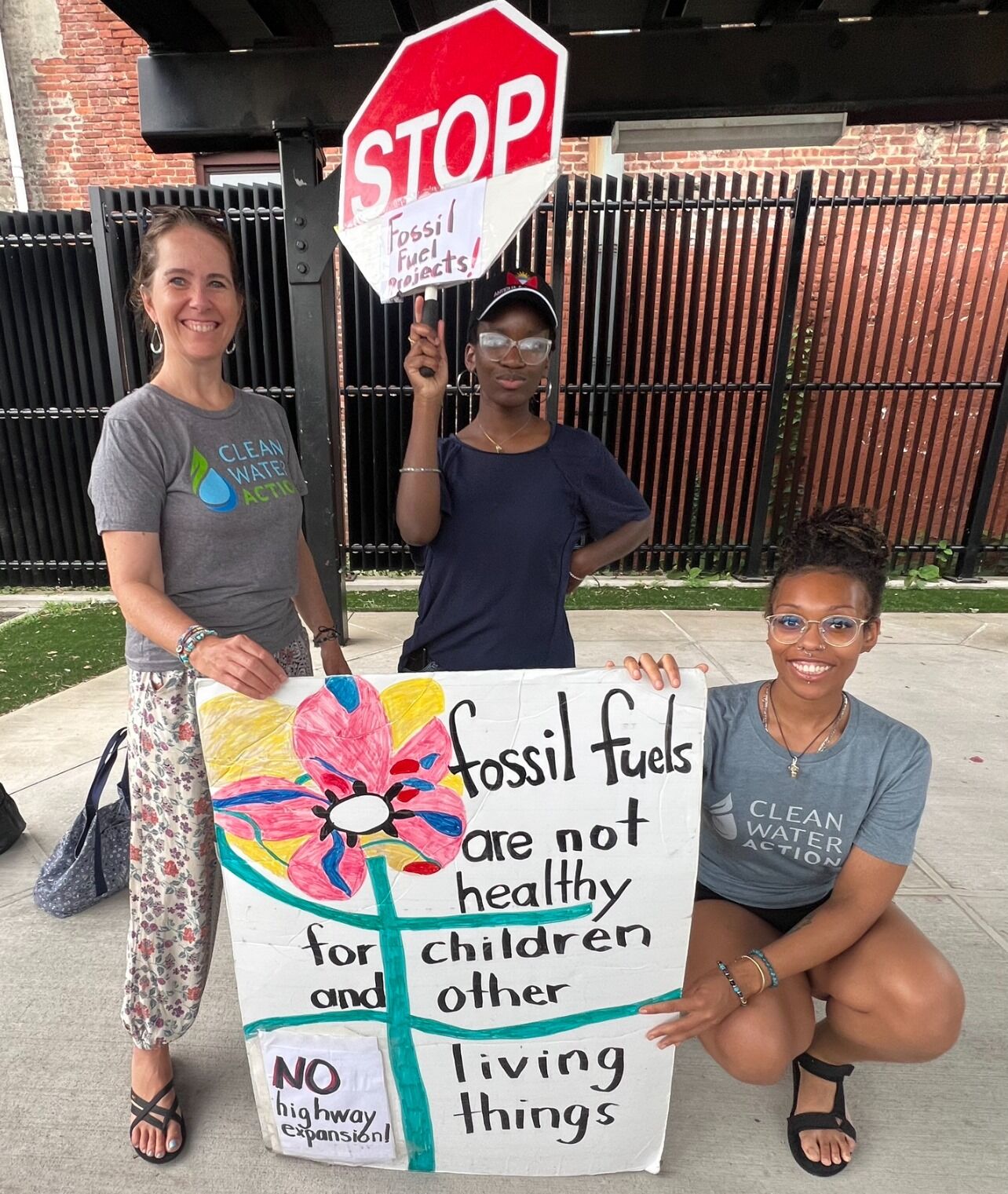 New Jersey Clean Water staff with signs: "Stop Fossil Fuels" "Fossil Fuels are not healthy for children and other living things"