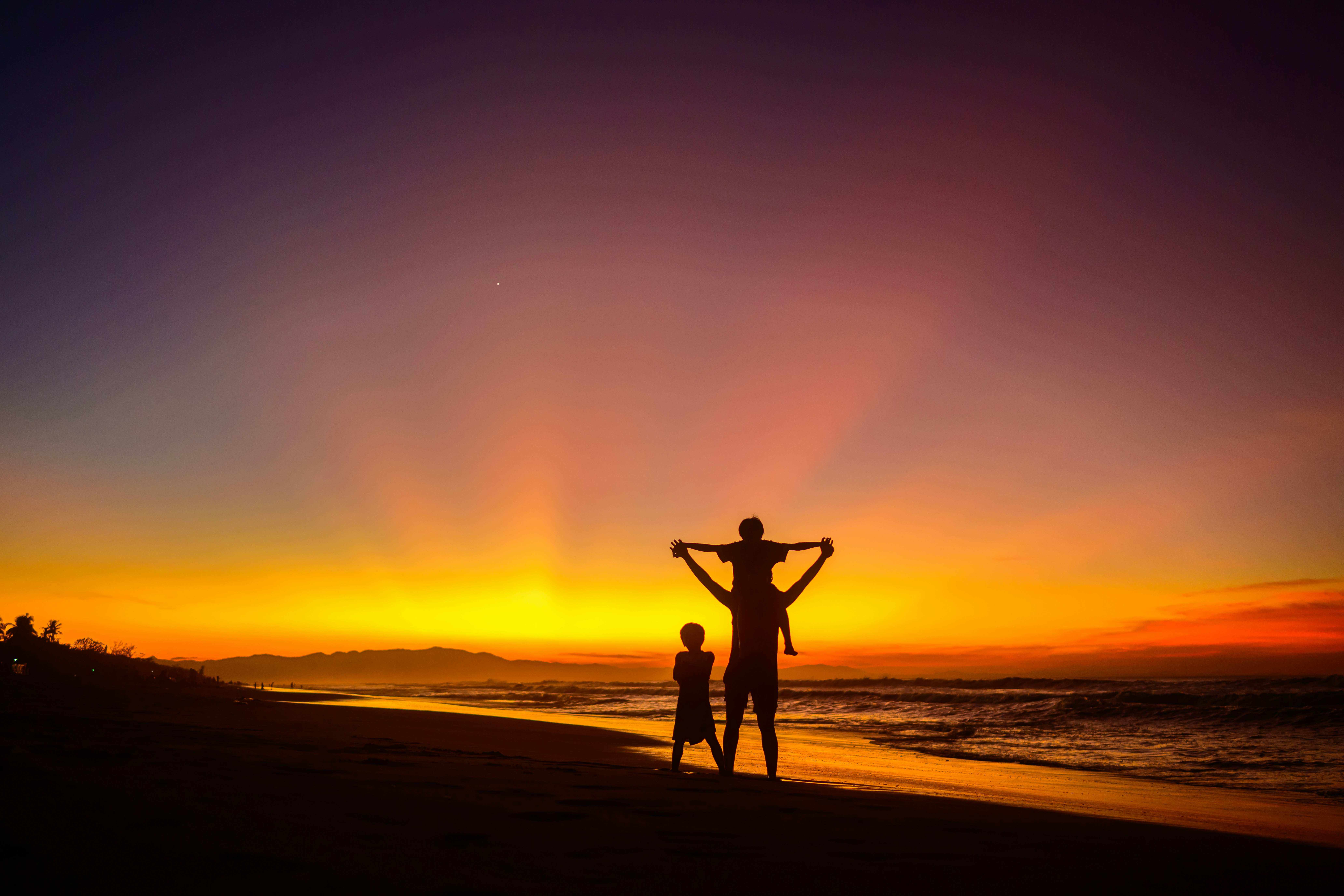 Image of a family on the beach at sunset
