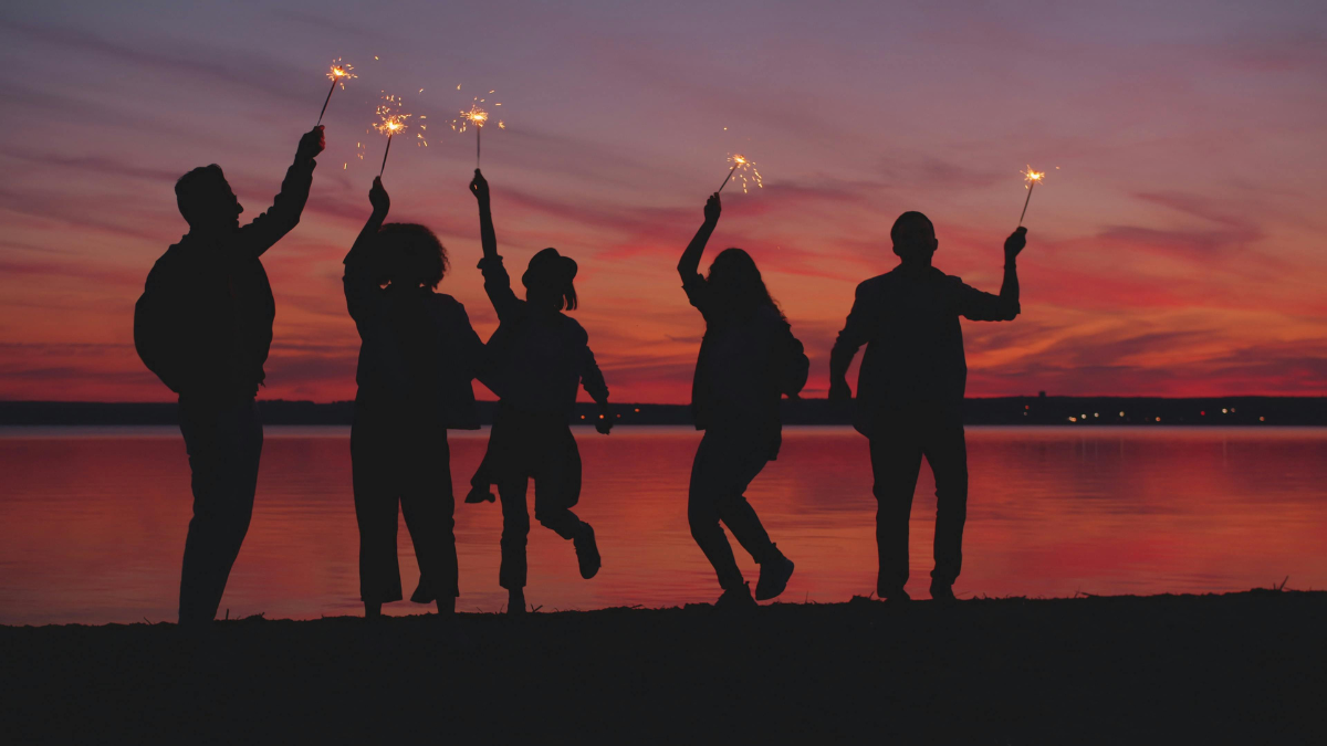 Friends celebrating at the lake at sunset
