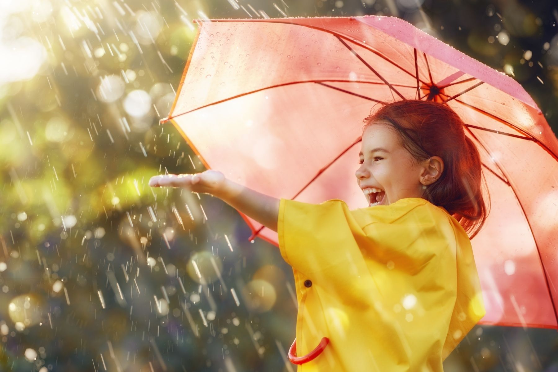 Photo of girl laughing under an umbrella in the rain