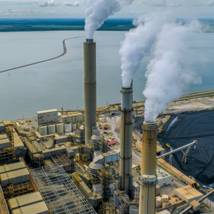 coal plant on a body of water - canva image.