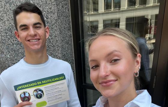 Alex Perez and Chloe Kintop pose with informational flyers about ReThink Disposable